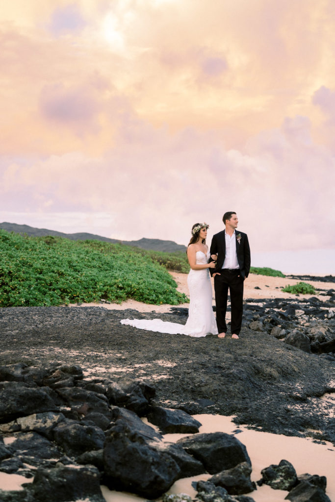 Bride and groom on the beach posing for elopement photos in Hawaii.