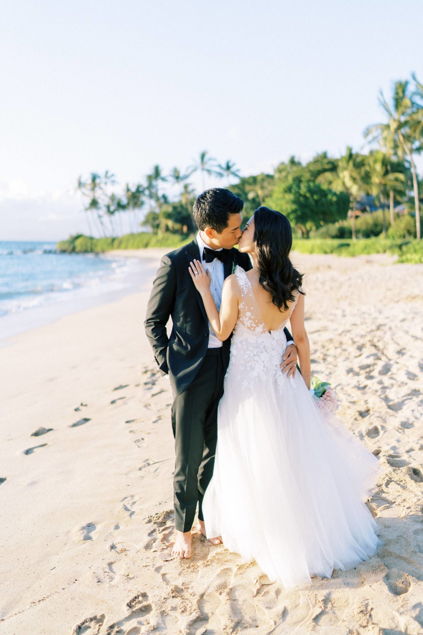 Newlyweds kissing at the beach in Hawaii