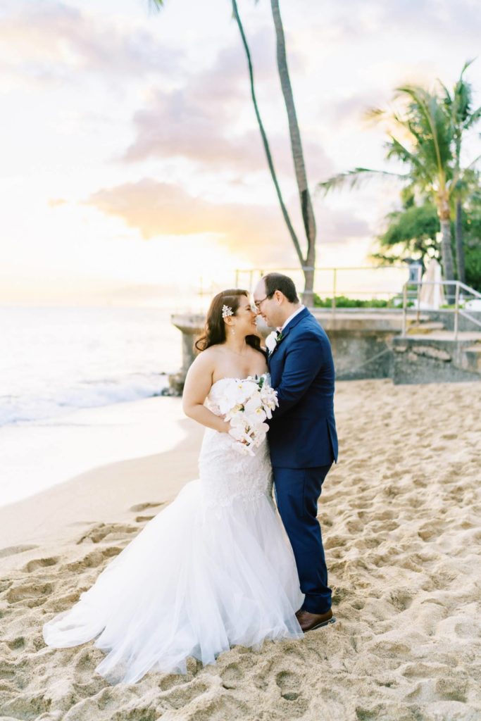 Newlyweds looking into each others eyes Oahu Wedding at The Halekulani Hotel Beach during sunset