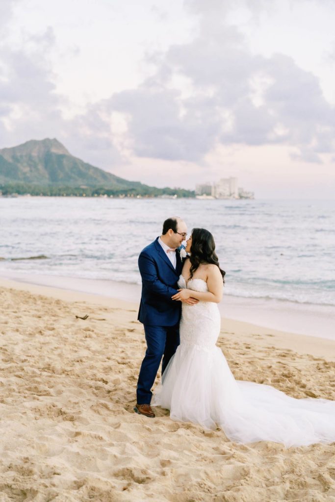 Newlyweds looking into each others eyes Oahu Wedding at The Halekulani Hotel Beach during sunset