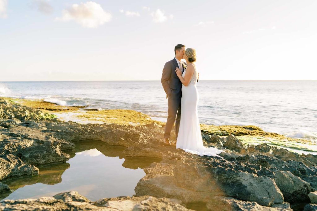 Husband and wife kissing by the beach Intimate Oceanside Elopement on Oahu