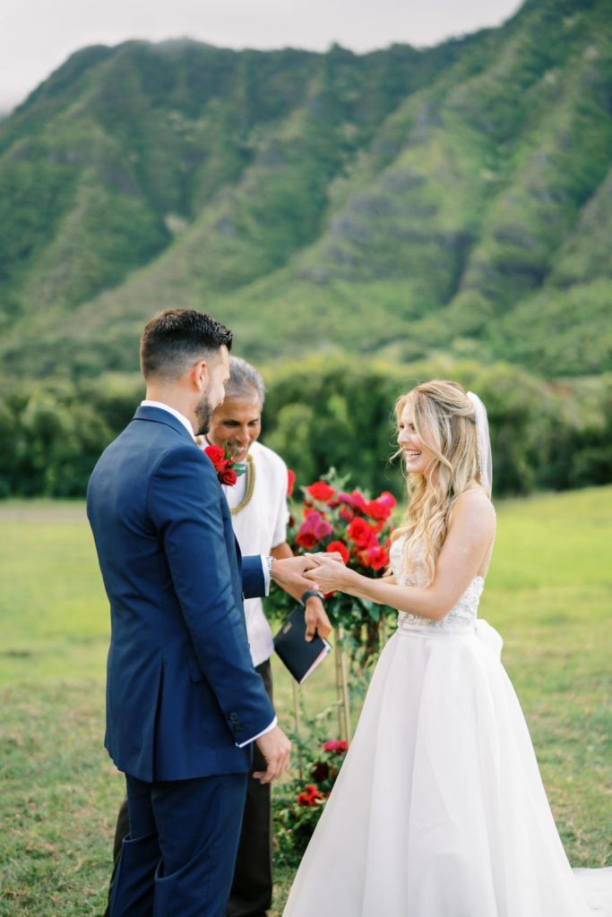 Bride putting wedding ring on groom Intimate Elopement at Kualoa Ranch on Oahu