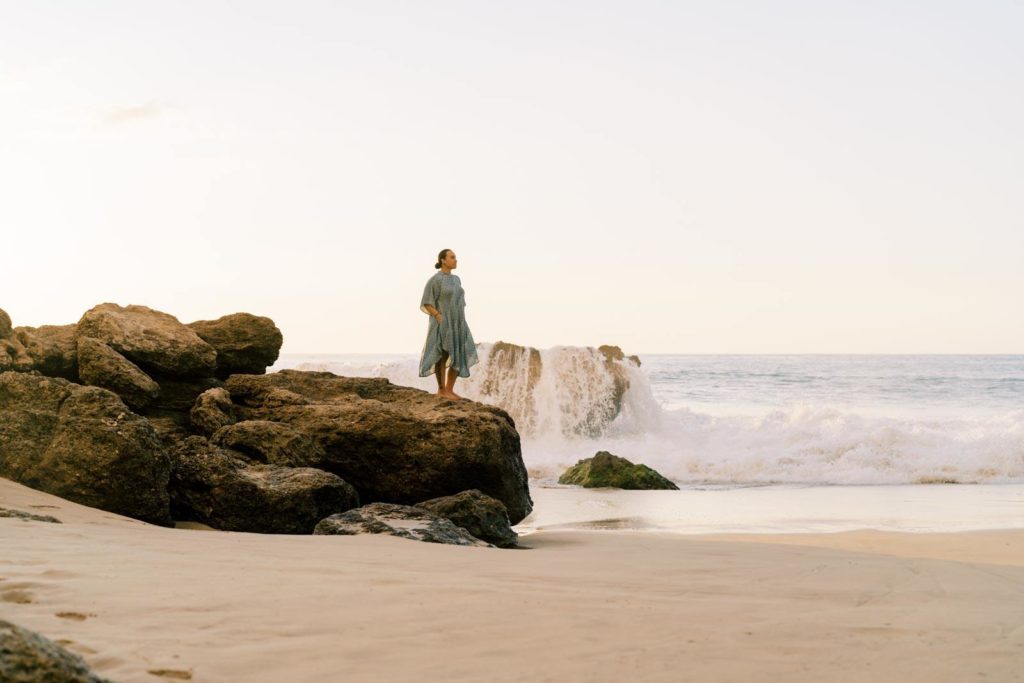 Woman standing on the rocks to the shore of Waianae beach in Oahu Hawaii Personal branding session