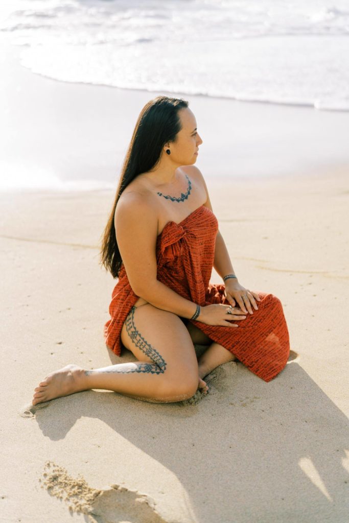 Woman sitting on the sand in Oahu Hawaiian Culture