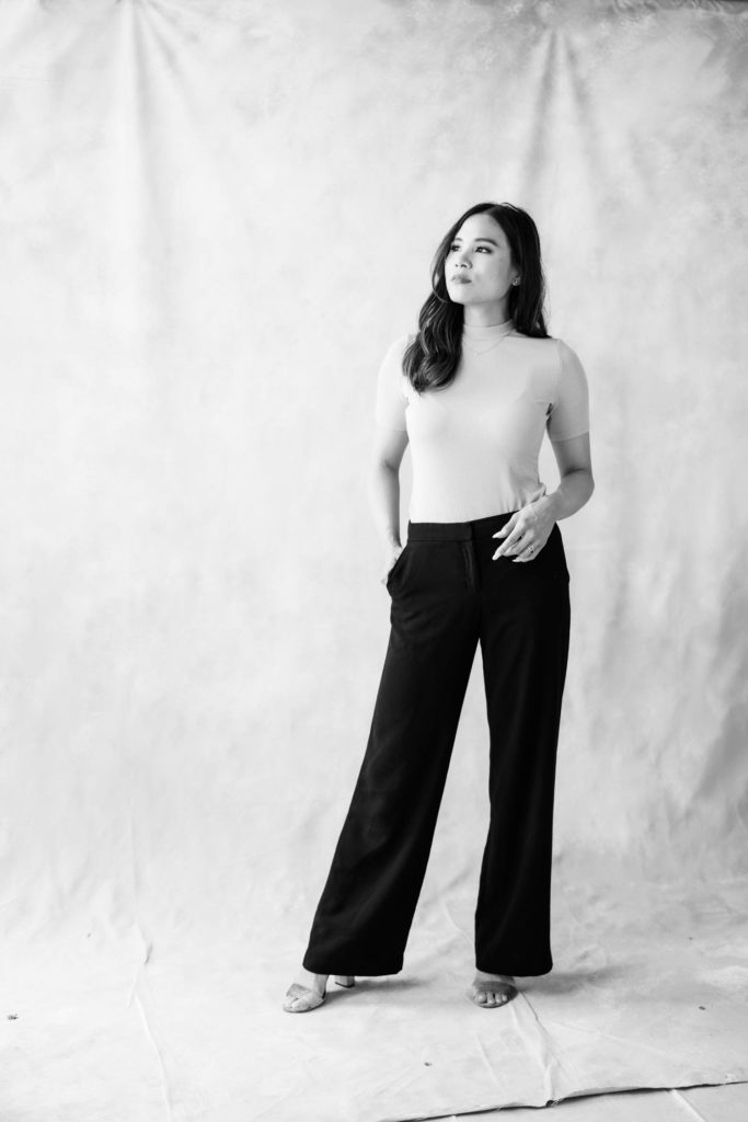 Black and white photo of a Woman in grey blouse and black trousers looking away from the camera a branding session