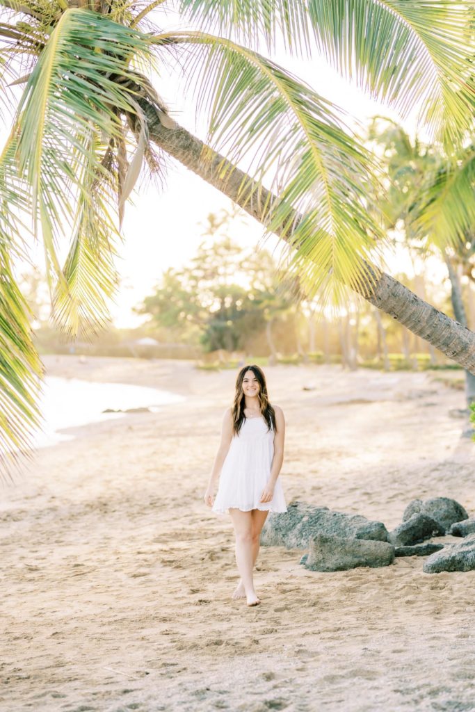 Girl in white dress walking at the beach barefoot
