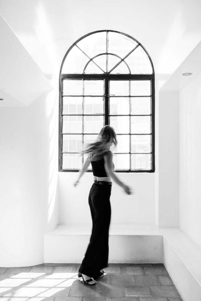 Blur photo of a woman dancing by the window