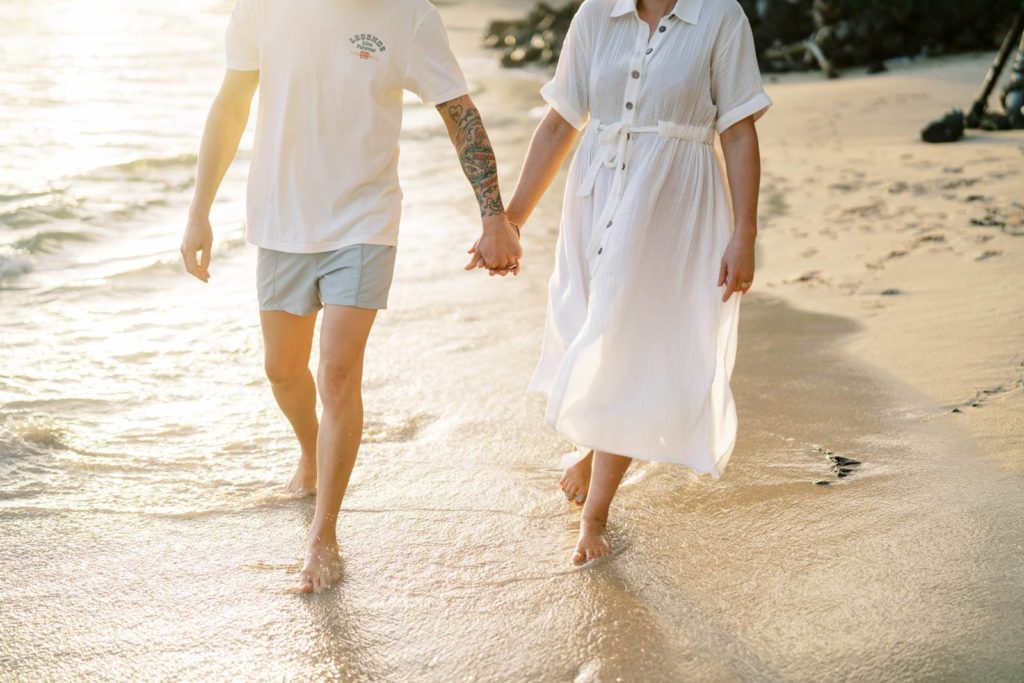 Couple walking by the beach during sunrise