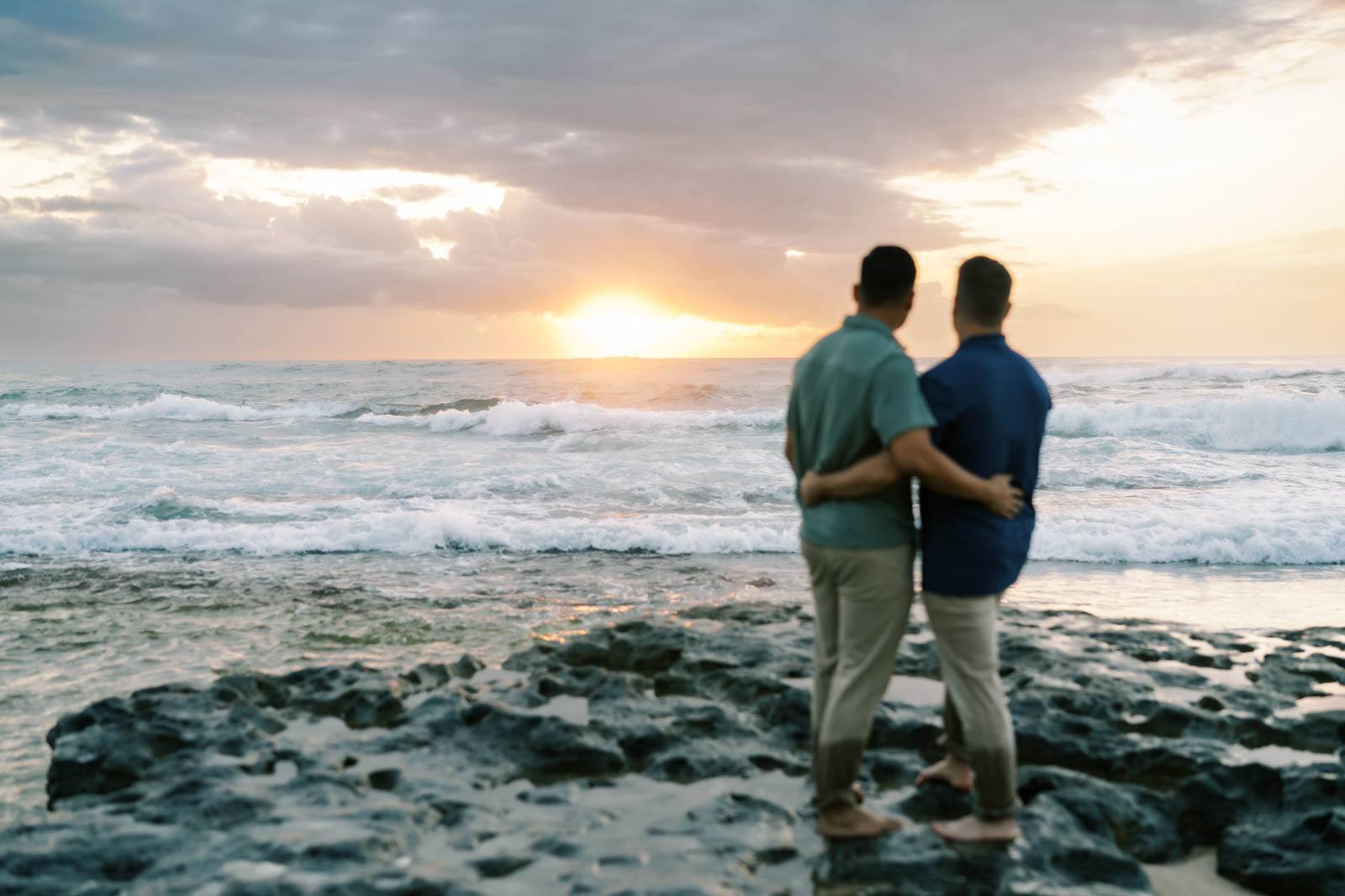 Oahu Engagement Session LGBTQ couple looking at sunset on the Haleiwa Beach