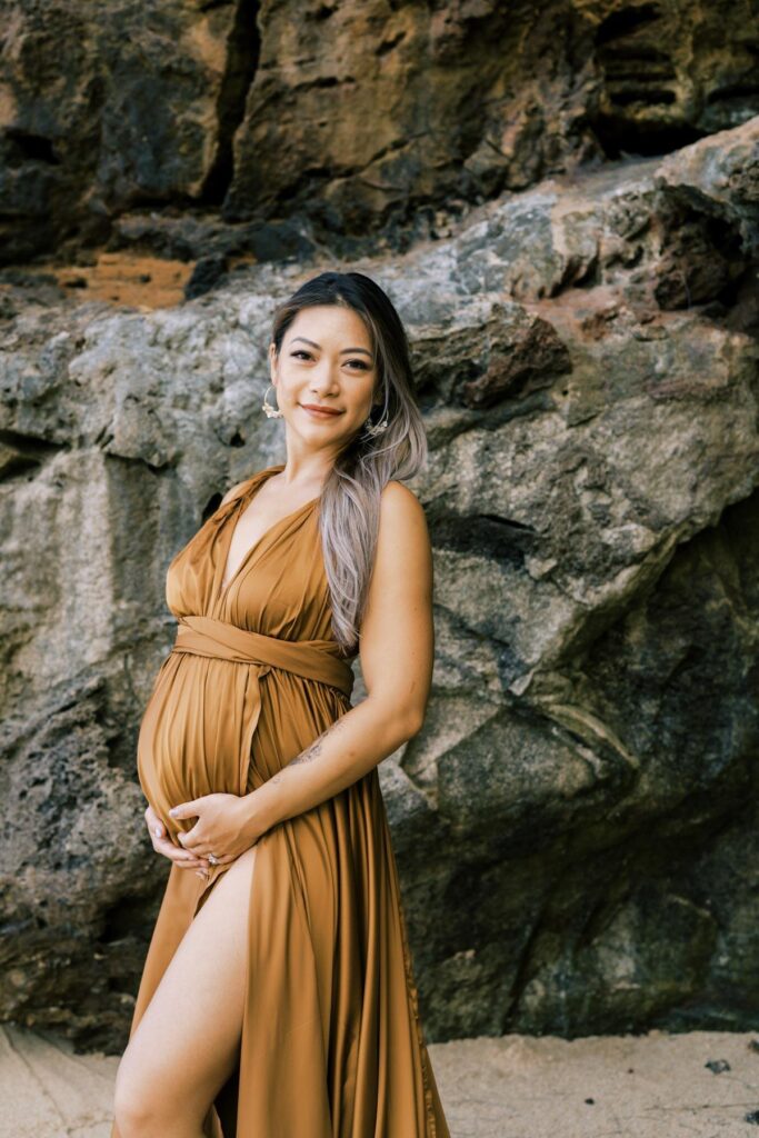 Pregnant woman wearing a brown dress at Laie beach