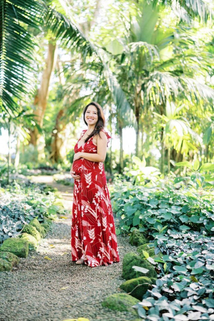 A Pregnant woman smiling vibrantly on her Pregnancy Photo Session at Oahu Botanical Garden