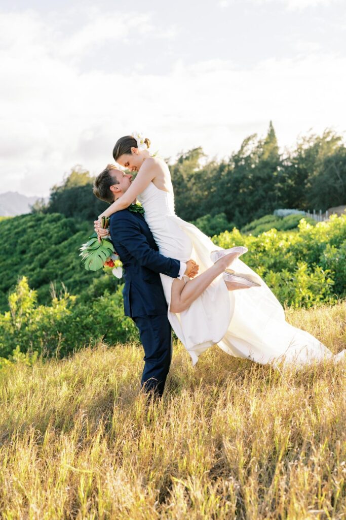 Newlyweds kissing on top of the hill, the groom lifted the bride Wedding on Kauai