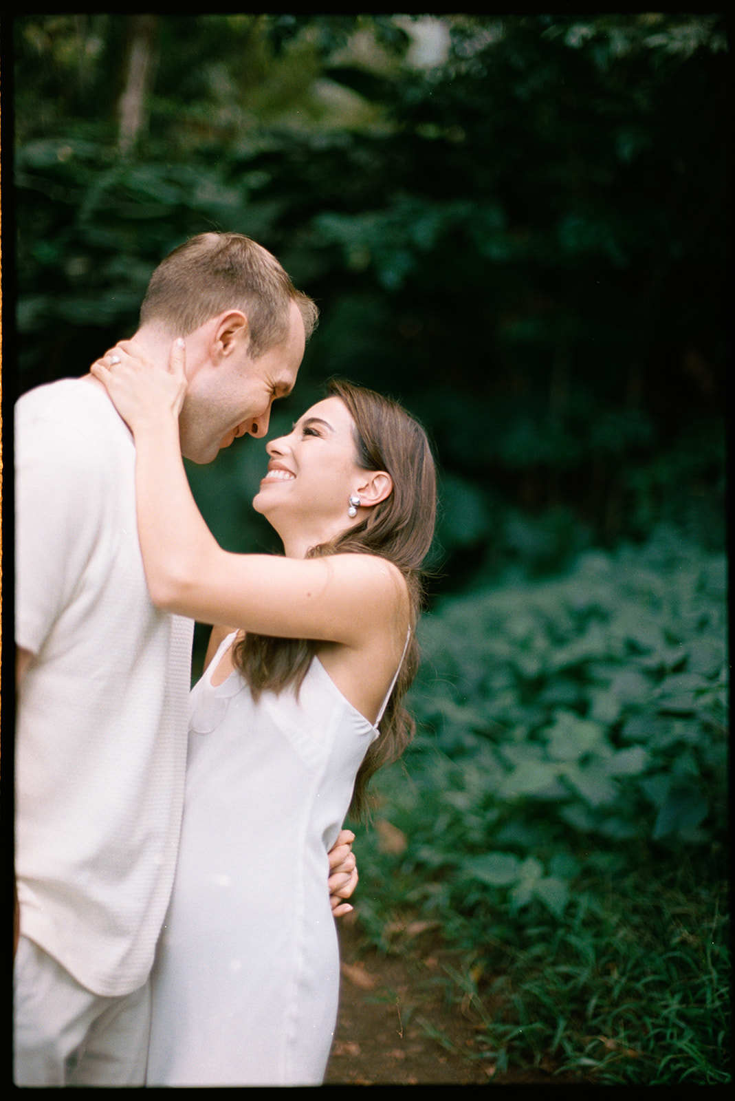 35 mm film photo of a newly engaged couple holding eachother in a garden on Oahu